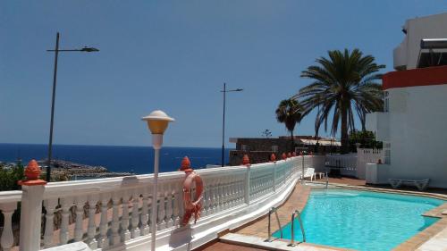 una persona de pie junto a una piscina en un balcón en Bonaire, en Puerto Rico de Gran Canaria