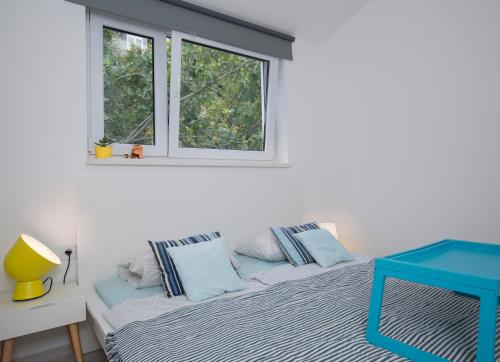 a bedroom with a bed with blue pillows and a window at Casa Blanca White House in Okrug Donji