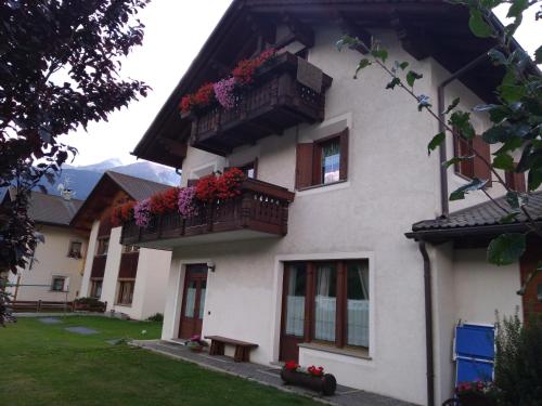 un edificio blanco con balcones y flores. en Casa dello Sciatore, en Bormio