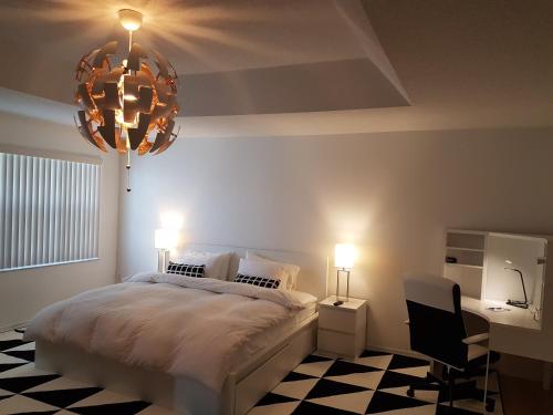a bedroom with a bed and a chandelier at Master Luxury Room in Sunrise