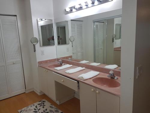 a bathroom with two sinks and two mirrors at Master Luxury Room in Sunrise