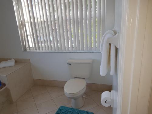 a bathroom with a white toilet and a window at Master Luxury Room in Sunrise