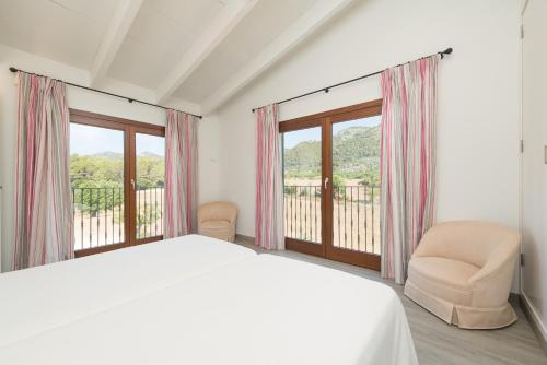 une chambre blanche avec un lit et une fenêtre dans l'établissement Villa S'Era, à Campanet