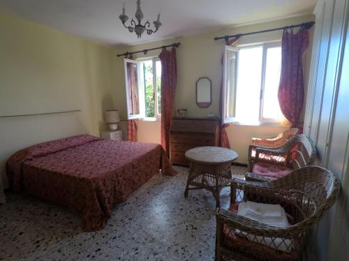 1 dormitorio con 1 cama, 1 silla y ventanas en Cinqueterre Holidays en Riomaggiore