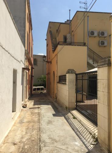 un callejón entre dos edificios con una valla en Corte Principe Amedeo, en Casarano