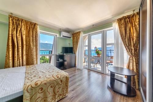 a bedroom with a bed and a view of the ocean at Hotel Ludmila in Gelendzhik