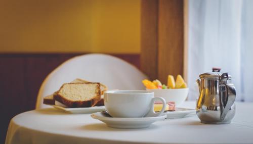 una mesa con una taza de café y un plato de pan en Gran Hotel Ovalle, en Ovalle