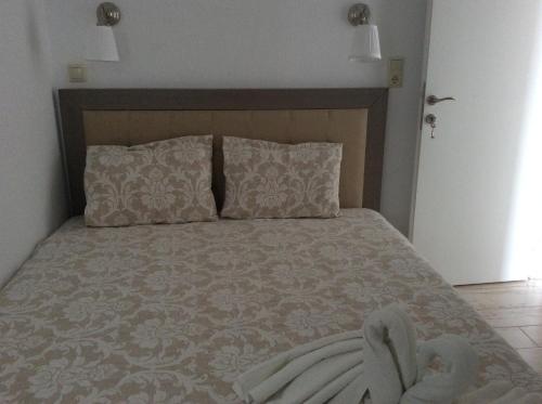 a bedroom with a large bed with two pillows at Marina in Nikiti