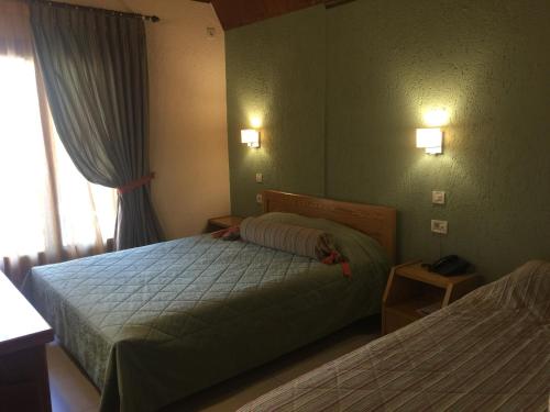 a hotel room with two beds and a window at Asimina Guesthouse, Eptalofos Parnassos in Eptalofos