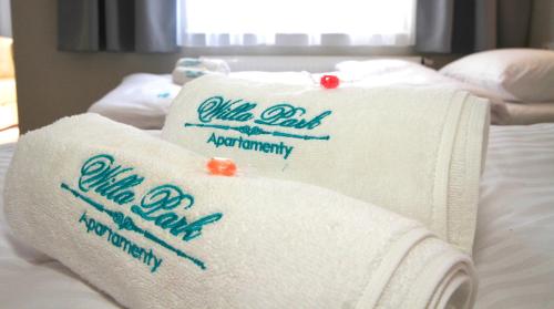a pile of towels sitting on a bed at Willa Park Apartamenty in Olsztyn