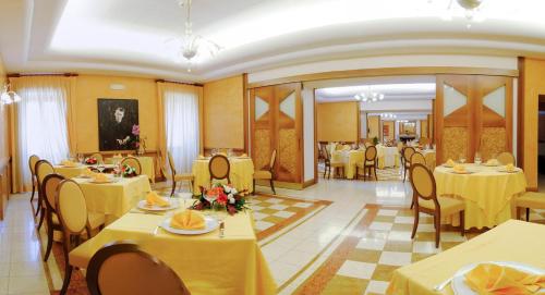a restaurant with yellow tables and chairs with yellow tables and chairs at Hotel&Ristorante Miramonti Palazzo Storico in Rieti