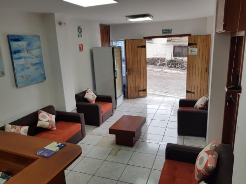 a waiting room with couches and chairs and a table at Gloria - Galápagos Inn in Puerto Ayora