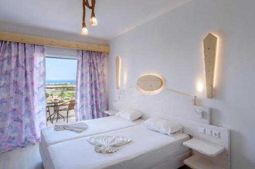 1 dormitorio con 2 camas y vistas al océano en Samos Sun, en Pythagoreio