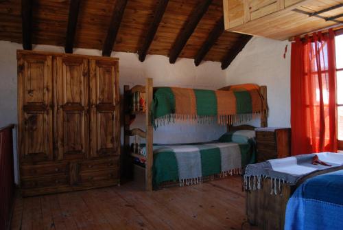 a bedroom with a bunk bed and wooden floors at Cabañas Wenelcklén in Uspallata