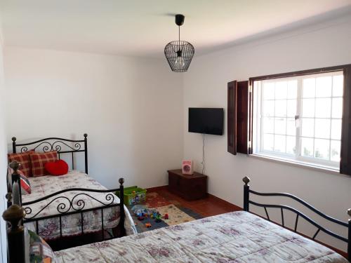 AmoreiraにあるCasa AMOReira de Óbidosのベッドルーム1室(ベッド2台、薄型テレビ付)