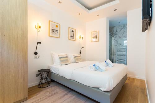 パリにあるCMG Saint Germain / Jardin du Luxembourg IIの白い壁とウッドフロアのベッドルーム1室(ベッド2台付)