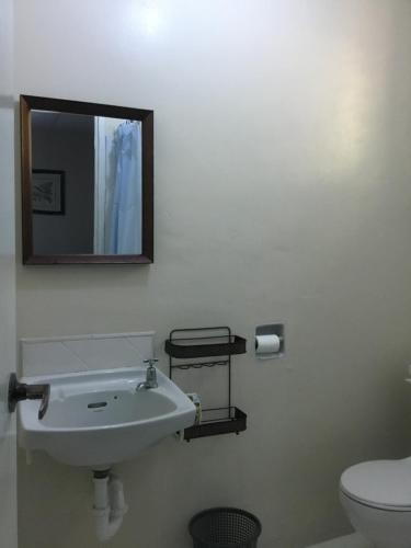 a bathroom with a sink and a mirror and a toilet at Harbour Vista Inn in Castries