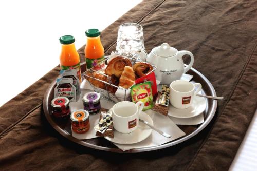 ein Tablett mit Frühstücksspeisen und Getränken auf dem Tisch in der Unterkunft Enzo Hotels Cannes-Écluse by Kyriad Direct in Cannes-Écluse