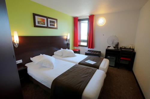 En eller flere senge i et værelse på Enzo Hotels Cannes-Écluse by Kyriad Direct