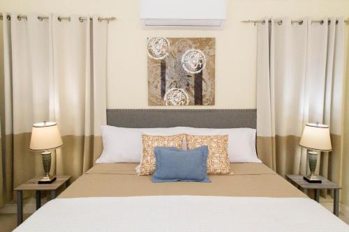 Villa Azul Ocho Rios في أوتشو ريوس: غرفة نوم بسرير كبير فيها مصباحين