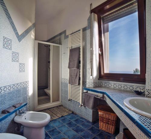 bagno con lavandino, servizi igienici e finestra di B&B Villa Patrizia a Ercolano