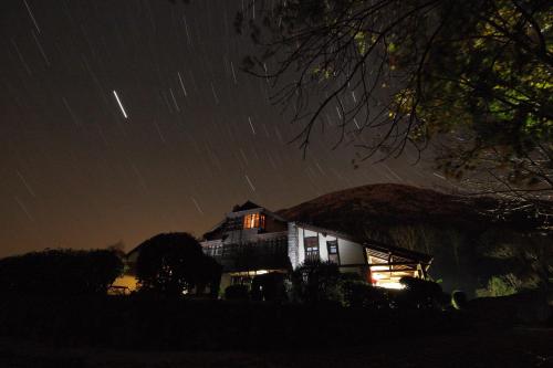 a house at night with star trails in the sky at La Montaña Mágica Hotel Rural in Vibaño