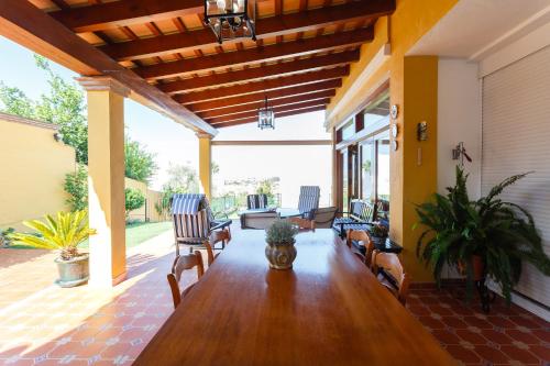 een woonkamer met een houten tafel en stoelen bij Bonito Chalet Con Vistas in Sanlúcar de Barrameda