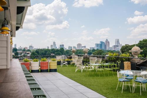 a balcony with tables and chairs and a view of the city at Hotel Clermont Atlanta, by Oliver in Atlanta