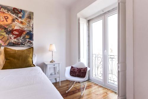 リスボンにあるTypical Mouraria by Homingのベッドルーム1室(ベッド1台、椅子、窓付)