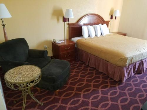 Habitación de hotel con cama y silla en Americas Best Value Inn Evansville East, en Evansville
