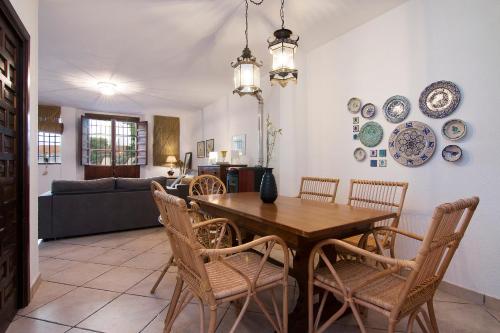 uma sala de jantar com uma mesa de madeira e cadeiras em tuGuest Pool House Albaicin em Granada
