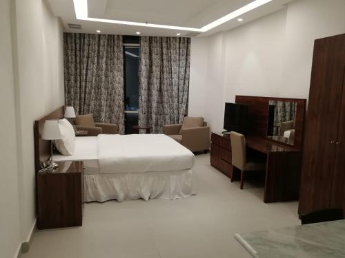 a hotel room with a bed and a desk at Sedra Residence in Kuwait
