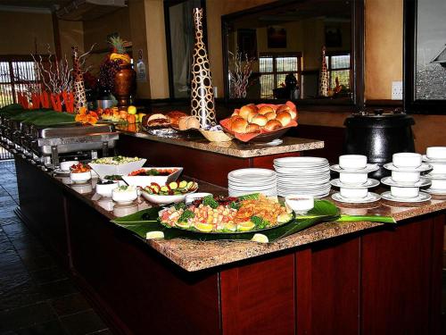 a buffet with plates and bowls of food on a counter at Ocean View Villas Unit G07 in Port Edward