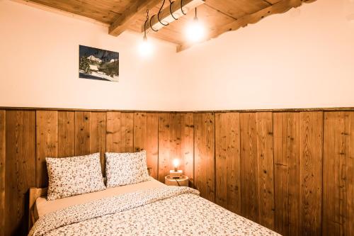 Un dormitorio con una pared de madera y una cama en "Pod Spadowcem", en Zakopane