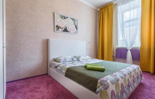 モスクワにあるApartment on Savvinskaya Naberezhnayaのベッドルーム1室(ベッド1台付)、黄色いカーテン付きの窓が備わります。