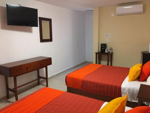 a hotel room with two beds and a flat screen tv at Hotel Santa Lucia del Bosque in San Luis Potosí