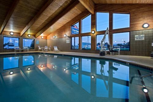 a large swimming pool in a building with windows at AmericInn by Wyndham Iowa Falls in Iowa Falls