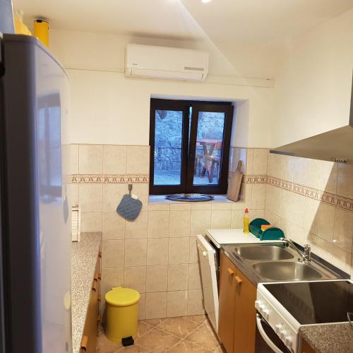 a small kitchen with a sink and a window at Holiday home Marija in Karlobag