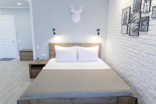 um quarto com uma cama e uma parede de tijolos em Studio Suite near Lake with Jacuzzi em Sumy