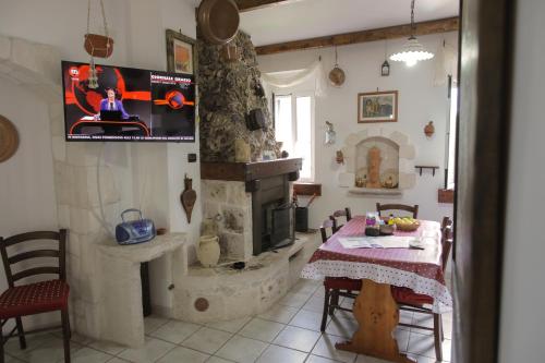 a living room with a table and a stone fireplace at Il Casale Delle Principesse in Mattinata