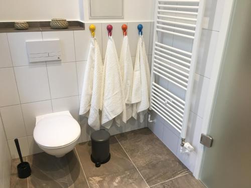 a bathroom with a toilet and towels on a wall at Ferienwohnung Atze in Berlin