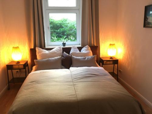 ベルリンにあるFerienwohnung Atzeのベッドルーム(白い大型ベッド、ランプ2つ付)