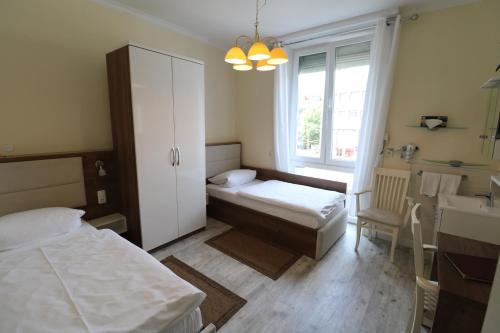 a small room with two beds and a sink at Hotel Boritzka in Hamburg