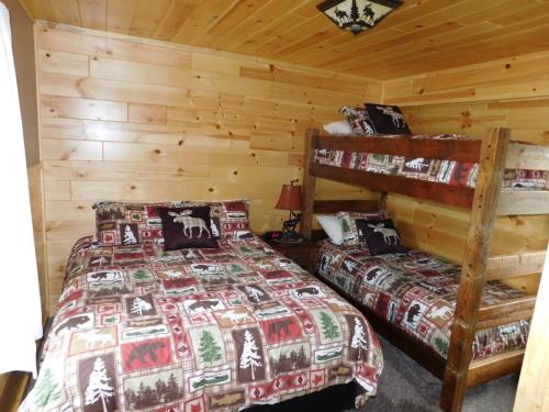 een slaapkamer met 2 bedden in een blokhut bij Loon Lodge in Phelps