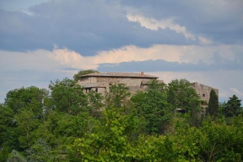 um edifício antigo no topo de uma colina com árvores em Feudi Spada casa vacanze em Orvieto