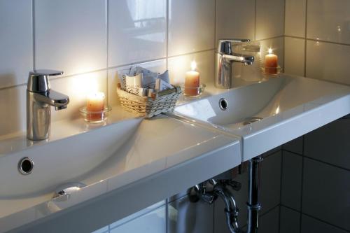 two sinks in a bathroom with candles on it at Hotel Central in Nyíregyháza