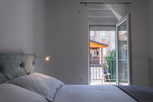a bedroom with a bed and a sliding glass door at Go2Zagreb Chick Apartment in Zagreb