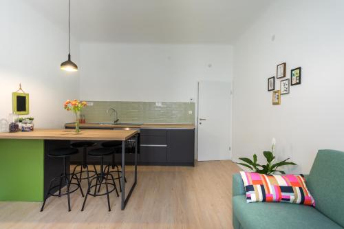 a kitchen with a counter and a table and a couch at Go2Zagreb Chick Apartment in Zagreb