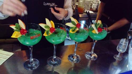 a group of martini glasses with fruit on a table at Pałac Spichrz in Borcz