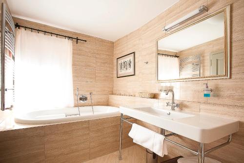 a bathroom with a sink and a tub and a mirror at Hotel Krčínův Dům in Český Krumlov